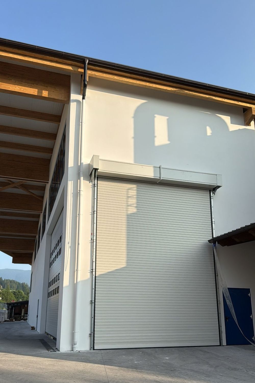 Serranda industriale su capannone, con portone sezionale con finestrature sullo sfondo