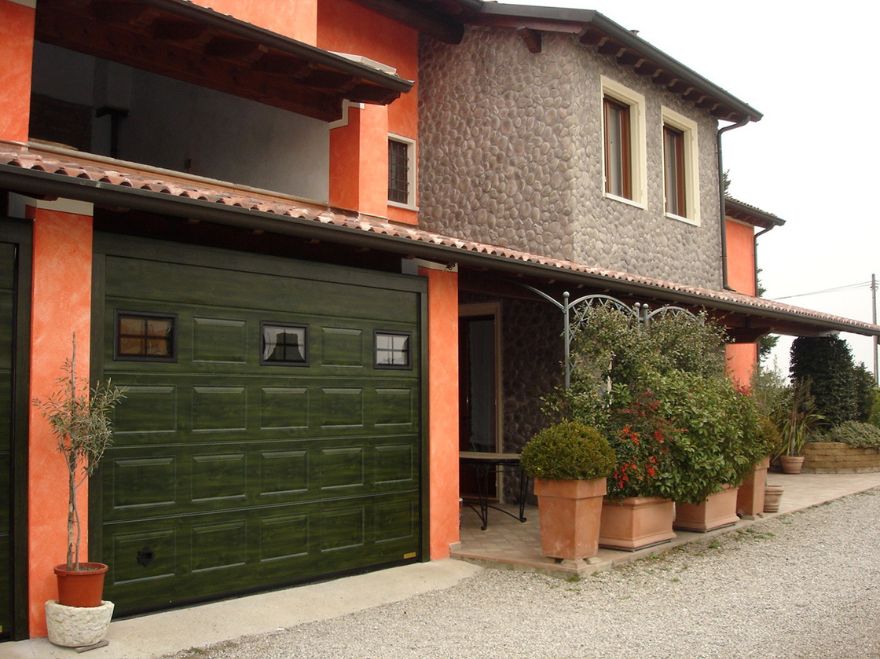 Villa con portone sezionale effetto legno verde