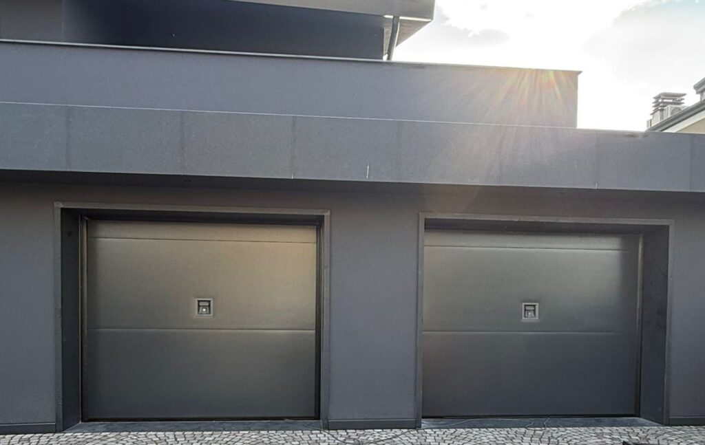 Due portoni sezionali O&O senza guide a soffitto color antracite su una villa moderna in provincia di Vicenza